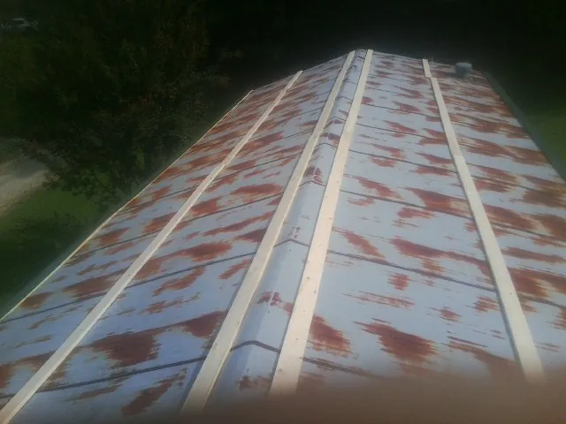 Rusted metal roof panels with new wood purlins before replacement — Storm Damage Roof Repair in Becker by Roofing Brothers