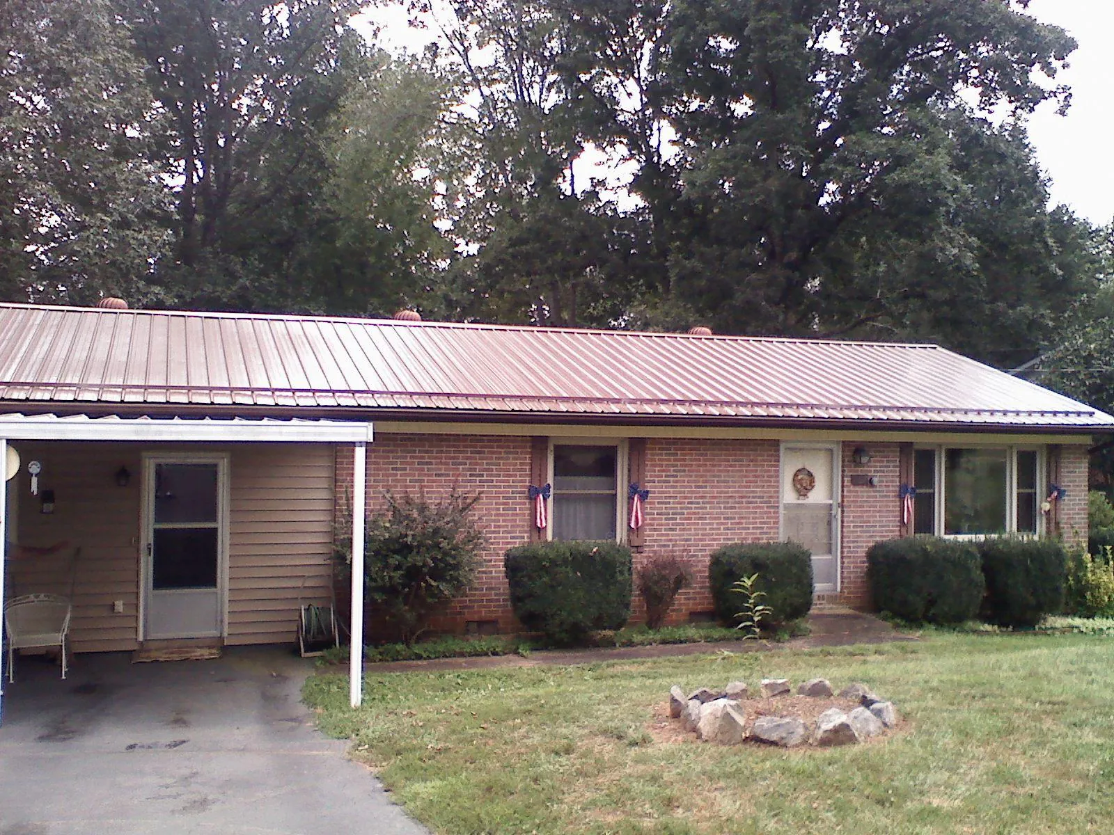 Bronze metal roof and carport on a brick ranch home — Roof Repair work by our crew in Becker
