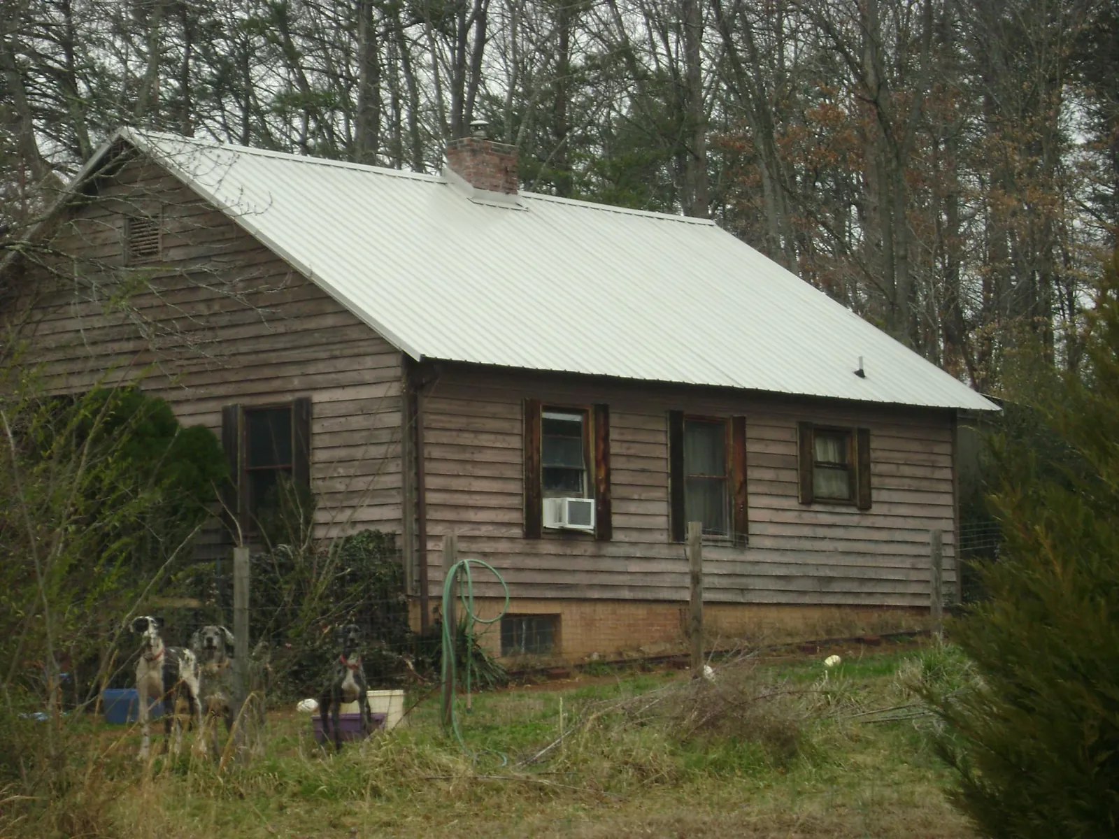 White metal roof on an old wood sided farmhouse, from a Metal Roof Installation job in Becker